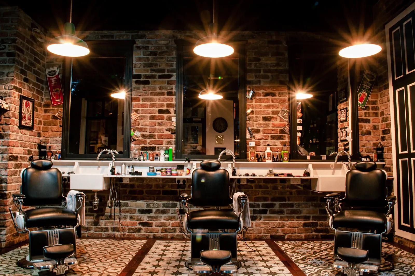 Interior de la barbería con sillones de cuero, espejos y luz cálida